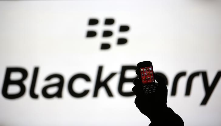 © Reuters. Man is silhouetted against a video screen with Blackberry logo as he pose with Blackberry Q10 in this photo illustration taken in the central Bosnian town of Zenica