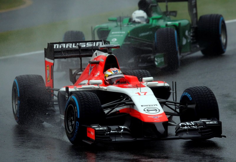 © Reuters. Marussia Formula One driver Bianchi of France drives in front of Caterham Formula One driver Kobayashi of Japan during the Japanese F1 Grand Prix at the Suzuka Circuit