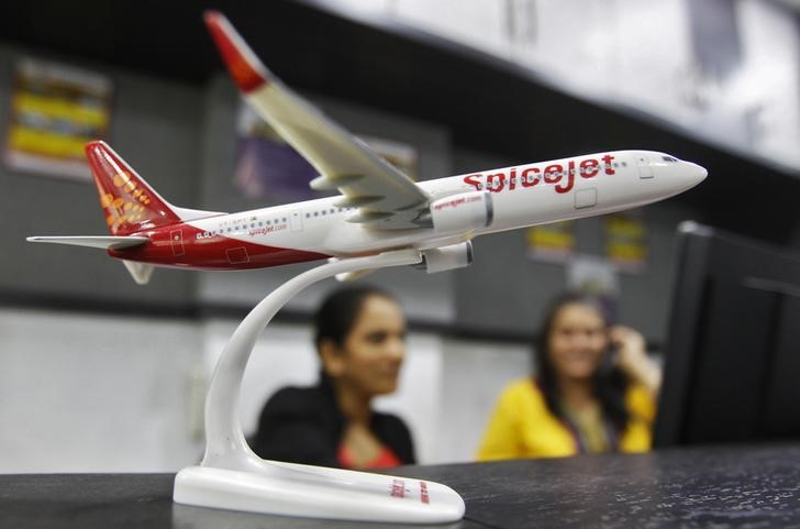 © Reuters. Employees work inside a travel agency office besides a model of a SpiceJet aircraft in Ahmedabad