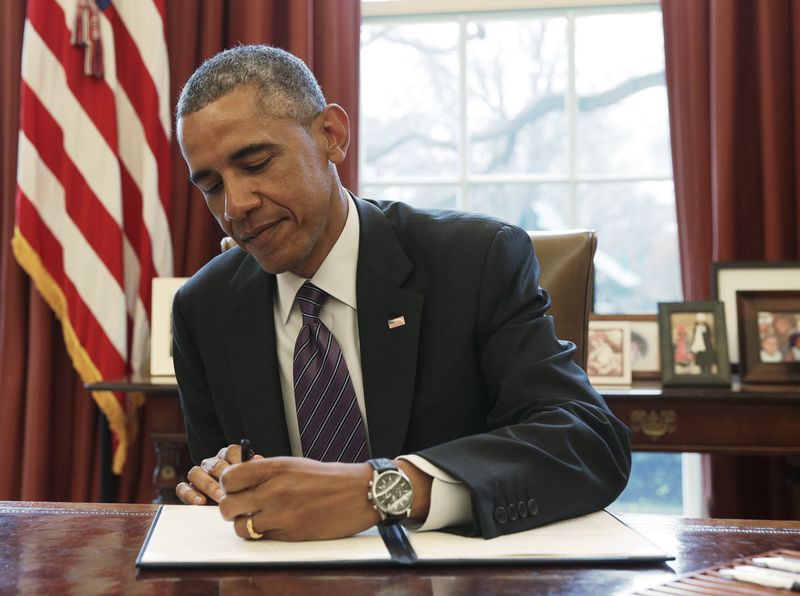 © Reuters. United States President Obama signs a Presidential Memorandum on paid leave for federal employees in the Oval Office of the White House in Washington