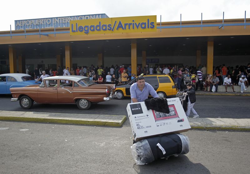 © Reuters. A passenger pushes a luggage cart after arriving on a charter flight from Tampa at the airport in Havana