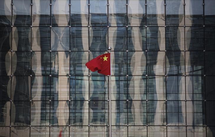 © Reuters. Chinese national flag flutters at the headquarters of a commercial bank on a financial street near the headquarters of the People's Bank of China, China's central bank, in central Beijing