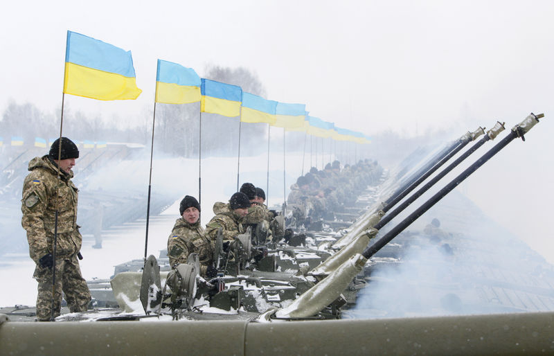 © Reuters. Ukrainian servicemen sit atop APCs during a ceremony to hand over weapons, military equipment and aircrafts to the army at a firing range outside Zhytomyr