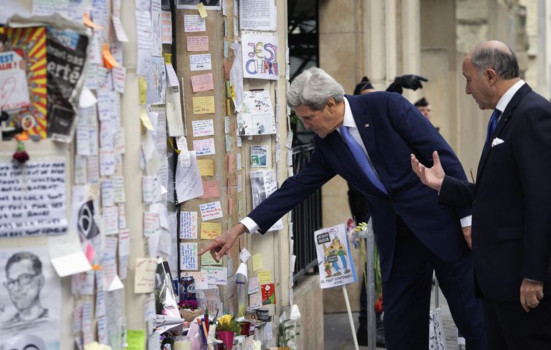 © Reuters. Kerry points to messages left at a memorial at the site of an attack at the Charlie Hebdo newspaper in Paris