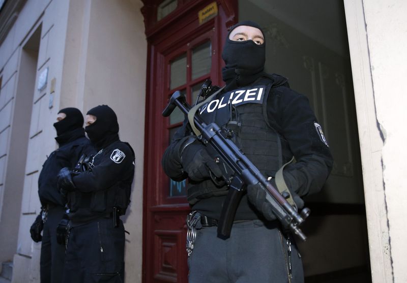 © Reuters. Policiais alemães na entrada de prédio de apartamentos em Berlim