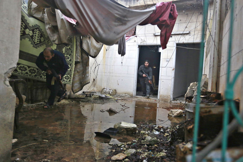 © Reuters. Combatentes rebeldes do Exército Sírio Livre correm armados dentro de casa danificada em Aleppo