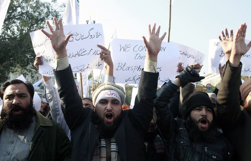 © Reuters. Manifestantes se enfrentan a la policía frente al consulado francés en Pakistán