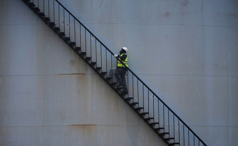 © Reuters. Trabalhador sobe escada do lado de fora de tanque de petróleo em refinaria da Total perto de Paris. 06/01/2015