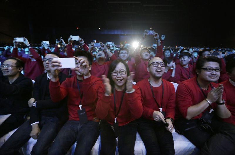 © Reuters. Xiaomi staff and users of Xiaomi phones react at the launch ceremony of the Mi Note in Beijing