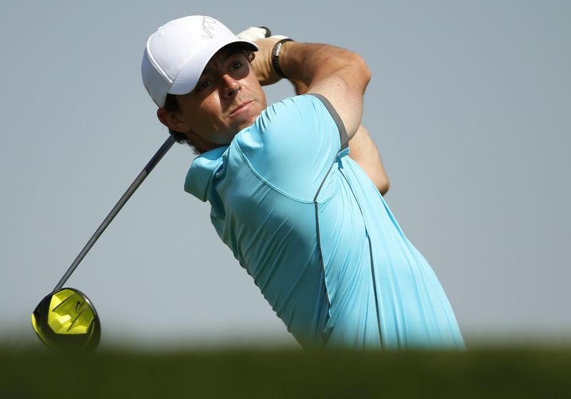 © Reuters. McIlroy tees off on the third hole during the Abu Dhabi Golf championship