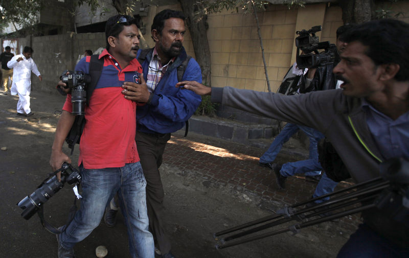 © Reuters. Fotógrafo da AFP Asif Hassan recebe ajuda após ser atingido por tiro durante protesto no Paquistão contra jornal francês Charlie Hebdo, em Karachi