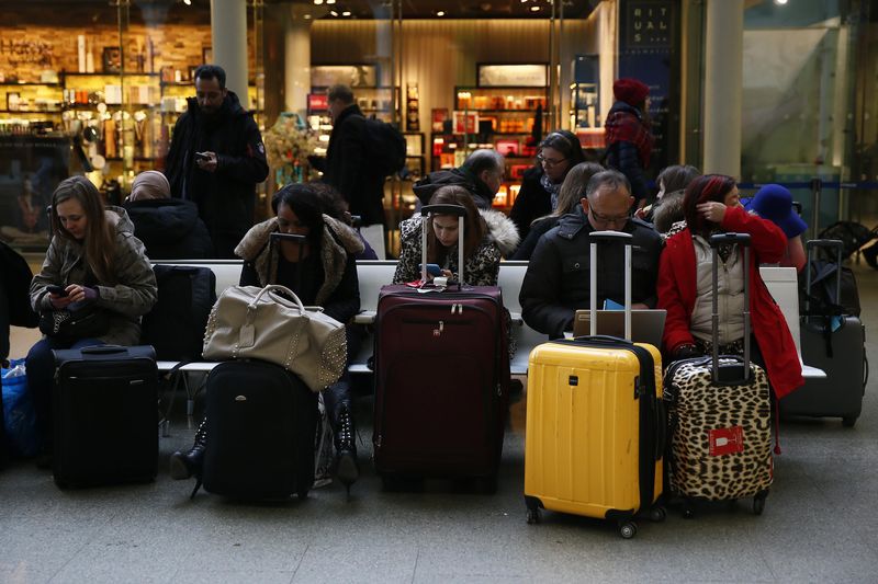 © Reuters. Passengers use their mobile phones at St Pancras International Station in London