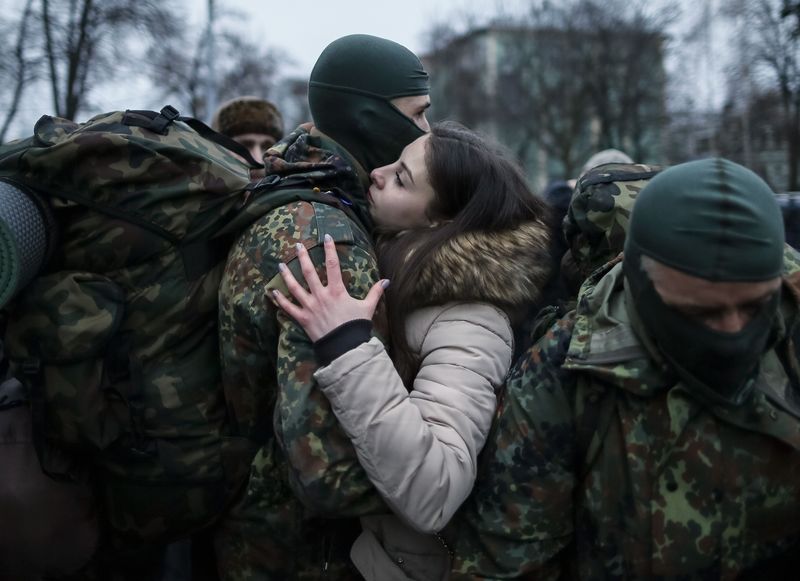 © Reuters. A new volunteer for the Ukrainian Interior Ministry's Azov battalion embraces his girlfriend before departing to the frontlines in eastern Ukraine, in central Kiev