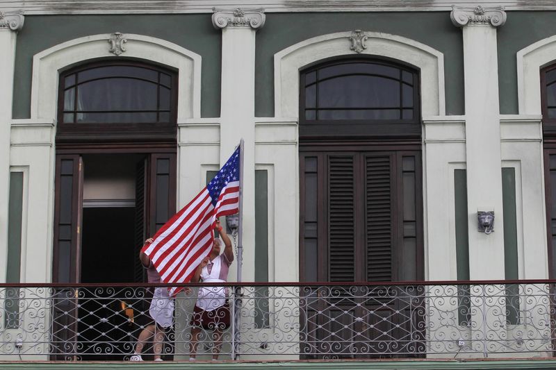 © Reuters. Hotel employees hoist a U.S. flag prior to the arrival of US Senator Patrick Leahy in downtown Havana