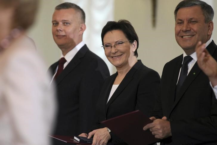 © Reuters. Prime Minister Kopacz smiles with Deputy Prime Minister Piechocinski and Defense Minister Siemoniak as they attend a swearing-in ceremony of the new cabinet at the Presidential Palace in Warsaw
