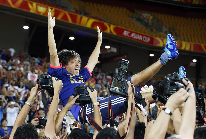 © Reuters. Japan's Yasuhito Endo is thrown in the air by team mates as he celebrates his 150th cap for the national team after the Asian Cup Group D soccer match win over Iraq at the Brisbane Stadium in Brisbane