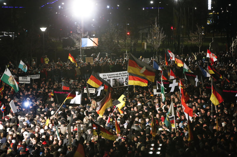 © Reuters. En la imagen de archivo, simpatizantes del movimiento antiinmigración Europeos Patrióticos contra la Islamización de Occidente (PEGIDA) agitan banderas durante una manifestación en Dresden