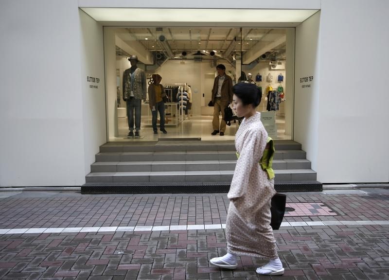 © Reuters. A kimono-clad woman walks in front of a luxury brand store at Tokyo's Ginza shopping district