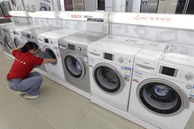 © Reuters. Sales assistant cleans a washing machine at Gome Electrical Appliance shop in Wuhan