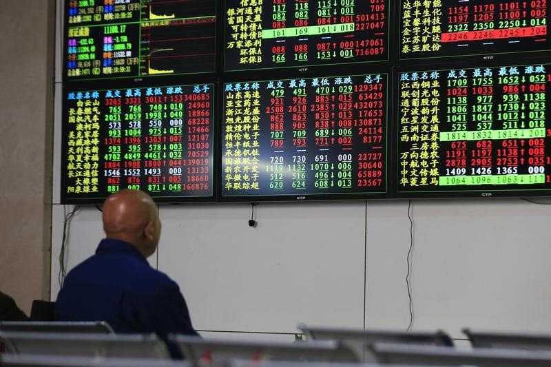 © Reuters. Investor looks at information displayed on an electronic screen at a brokerage house in Shanghai