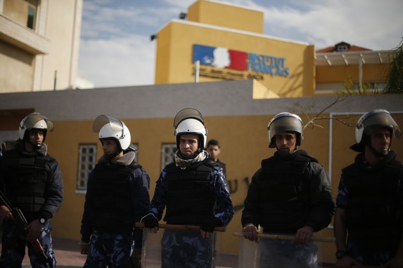 © Reuters. Palestinian riot police loyal to Hamas stand guard during a protest against satirical French weekly magazine Charlie Hebdo's cartoons of the Prophet Mohammad, outside the French Cultural Centre in Gaza