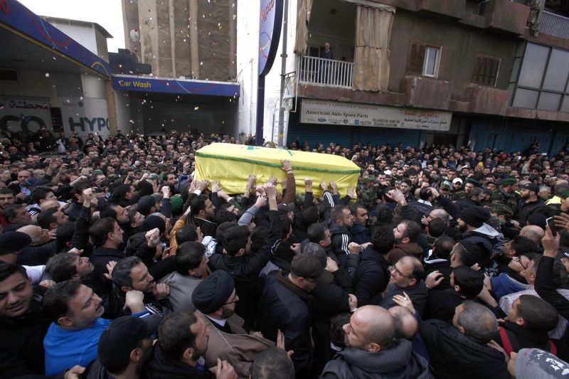 © Reuters. Rose buds are thrown over Lebanon's Hezbollah members and supporters while they carry the coffin of Jihad Moughniyah during his funeral in Beirut's suburbs