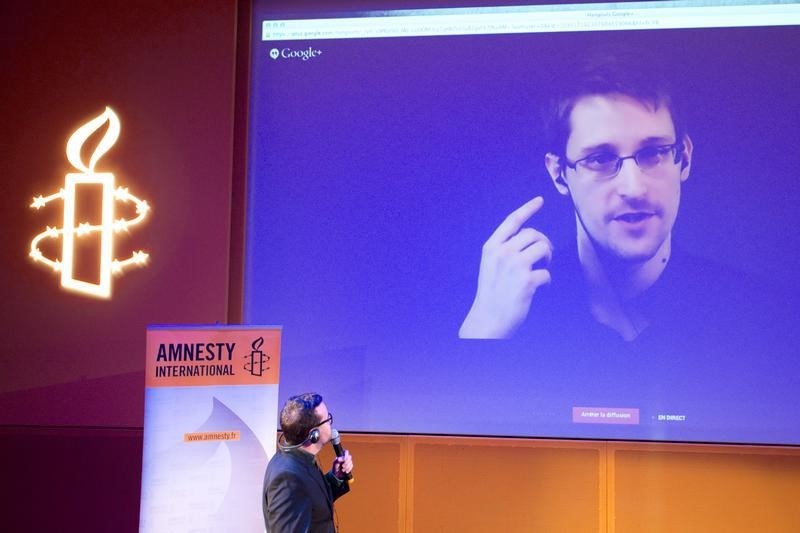 © Reuters. Former US National Security Agency contractor Edward Snowden, who is in Moscow, is seen on a giant screen during a live video conference for an interview as part of Amnesty International's annual Write for Rights campaign at the Gaite Lyrique in Paris