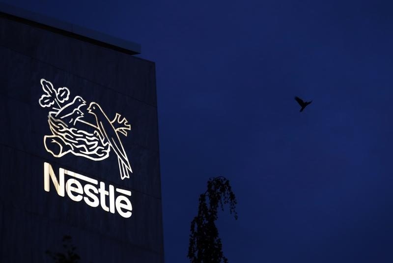 © Reuters. A bird flies past the logo at the headquarters of world food giant Nestle in Vevey