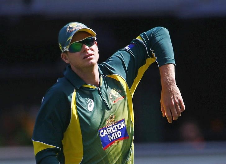 © Reuters. Australia's Smith stretches his shoulder after fielding a ball during their one day international tri-series cricket match against India at the Melbourne Cricket Ground