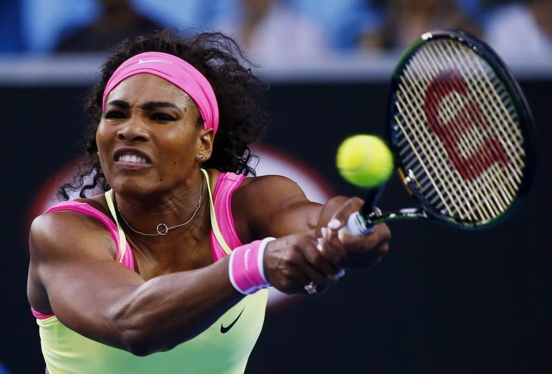 © Reuters. Williams of the U.S. hits a return to Van Uytvanck of Belgium during their women's singles first round match at the Australian Open 2015 tennis tournament in Melbourne