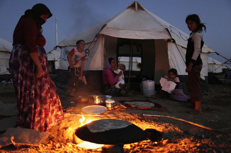 © Reuters. File photo of a woman from minority Yazidi sect, who fled violence in Iraqi town of Sinjar, making bread at Bajed Kadal refugee camp, southwest of Dohuk province