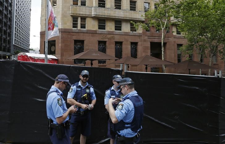 © Reuters. Policia autraliana monta guarda em frente a uma área isolada após ataque de um homem armado, em Sydney 