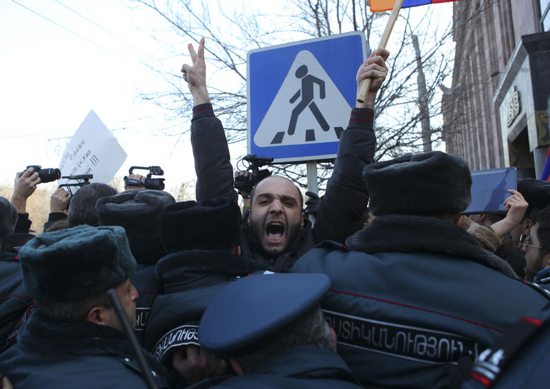 © Reuters. Полицейские сдерживают участников акции протеста у посольства РФ в Ереване