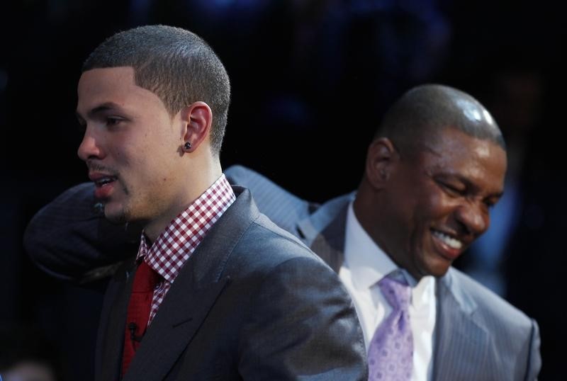 © Reuters. Doc Rivers, Head Coach of the Boston Celtics pats his son Austin Rivers, after Austin was selected by the Charlotte Hornets as the 10th overall pick in the 2012 NBA basketball Draft in Newark