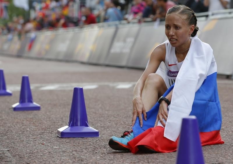 © Reuters. Russia's Olga Kaniskina sits on the ground after finishing second in the women's 20km race walk final at the London 2012 Olympic Games at The Mall