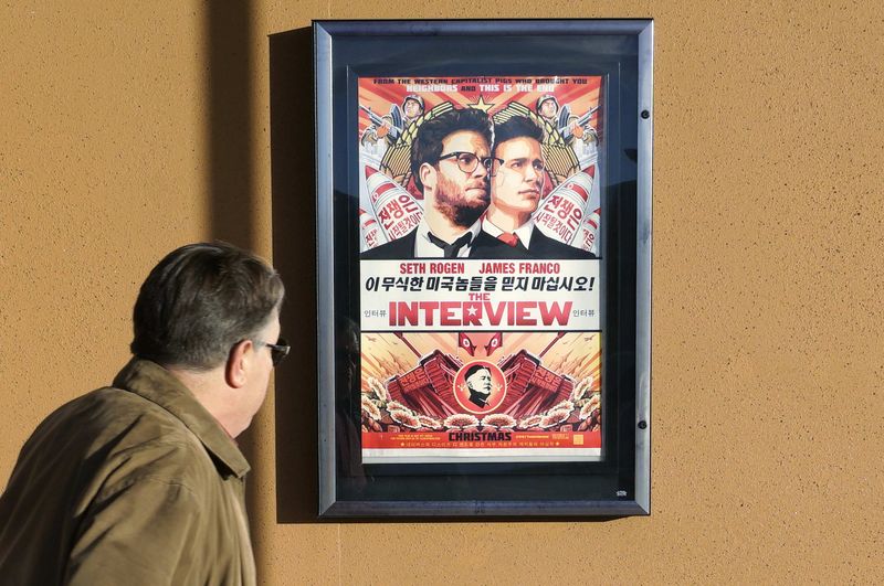 © Reuters. A man walks by poster for film "The Interview" outside Alamo Drafthouse theater in Littleton