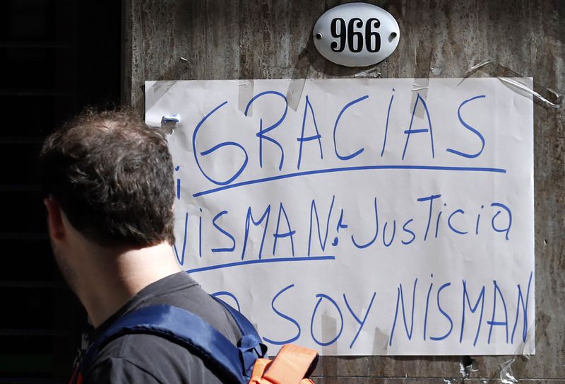 © Reuters. A man looks at a sign that reads "Thanks Nisman. Justice. I am Nisman" placed outside the office of the prosecutor who is investigating the death of prosecutor Alberto Nisman in Buenos Aires