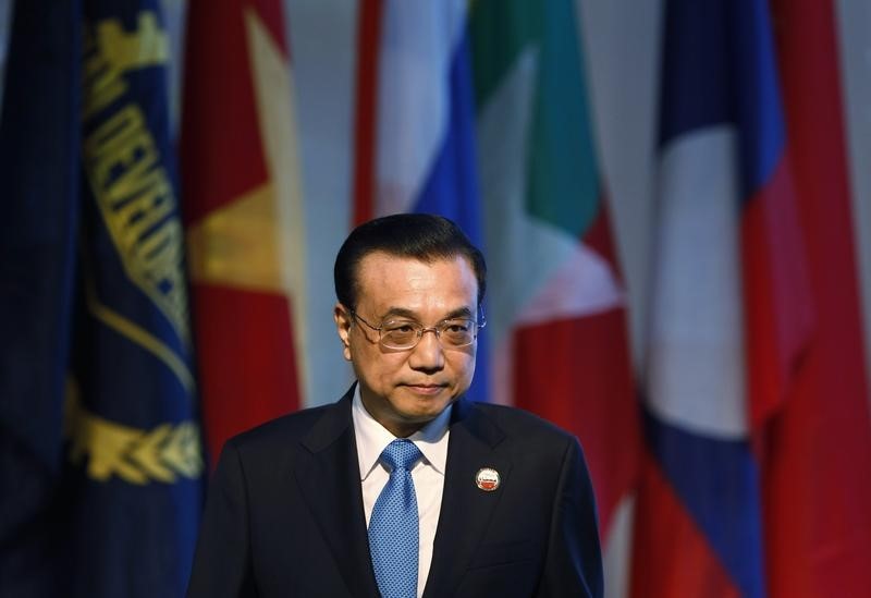 © Reuters. China's Premier Li Keqiang walks past national flags during the opening ceremony of the 5th Greater Mekong Subregion (GMS) Summit at a hotel in Bangkok