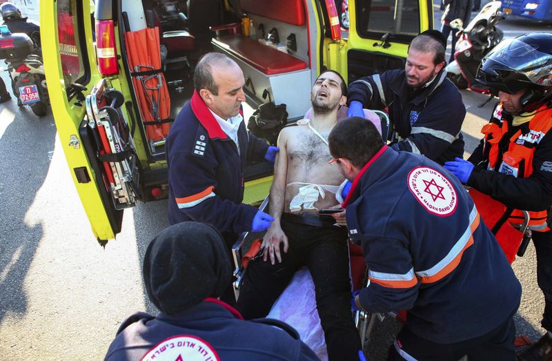 © Reuters. Médicos israelenses atendem homem ferido após ataque em ônibus de Tel Aviv