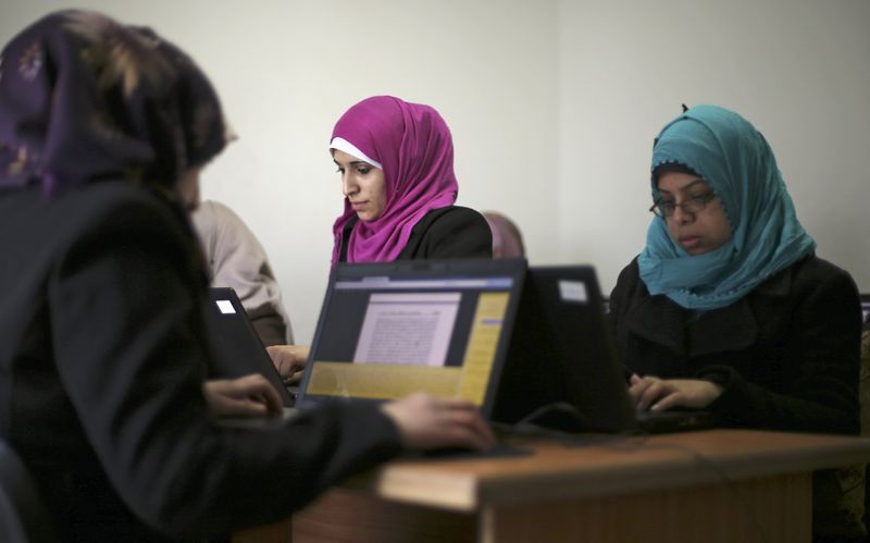 © Reuters. Palestinian employees process data on their laptops at Unit One in Gaza City