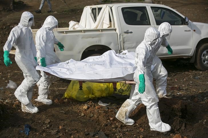 © Reuters. Trabalhadores de saúde carregam corpo de vítima de Ebola para ser enterrada em cemitério de Freetown, em Serra Leoa