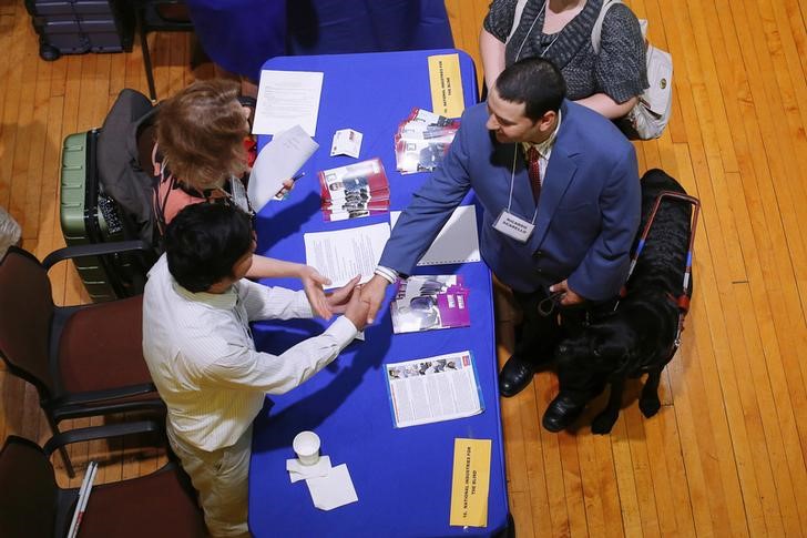 © Reuters. Job seeker Ricardo Scarello talks to representatives from the National Industries for the Blind at the fourth Annual Job Fair for Individuals with Visual Impairments in Cambridge