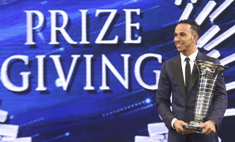 © Reuters. Hamilton holds his trophy during the 2014 FIA Gala Prize-Giving ceremony in Doha