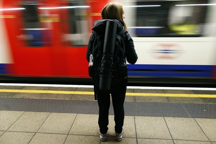 © Reuters. A woman waits for a London Underground train to stop at Oxford Circus station in central London