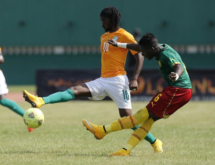 © Reuters. Ivory Coast's Gervinho fights for the ball with Oyongo of Cameroon during their African Nations Cup qualifying soccer match at the Felix Houphouet Boigny stadium in Abidjan