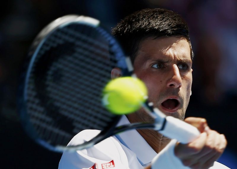 © Reuters. Djokovic of Serbia hits a return to Kuznetsov of Russia during their men's singles second round match at the Australian Open 2015 tennis tournament in Melbourne