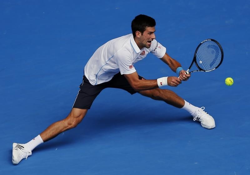 © Reuters. Djokovic of Serbia stretches to hit a return to Kuznetsov of Russia during their men's singles second round match at the Australian Open 2015 tennis tournament in Melbourne