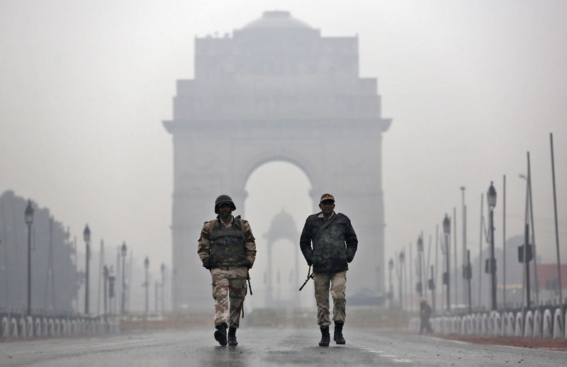 © Reuters. Indian security personnel patrol in front of India Gate as it rains in New Delhi