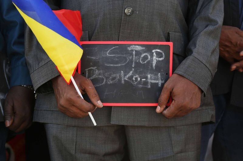 © Reuters. A man holds a sign that reads "Stop Boko Haram" at a rally to support Chadian troops heading to Cameroon to fight Boko Haram in Ndjamena