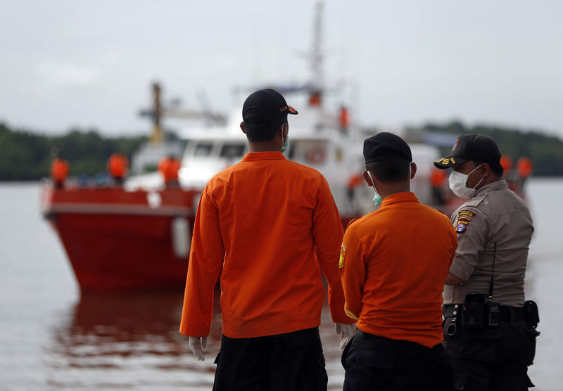 © Reuters. Buzos indonesios recuperan cuerpos cerca de fuselaje de avión de AirAsia